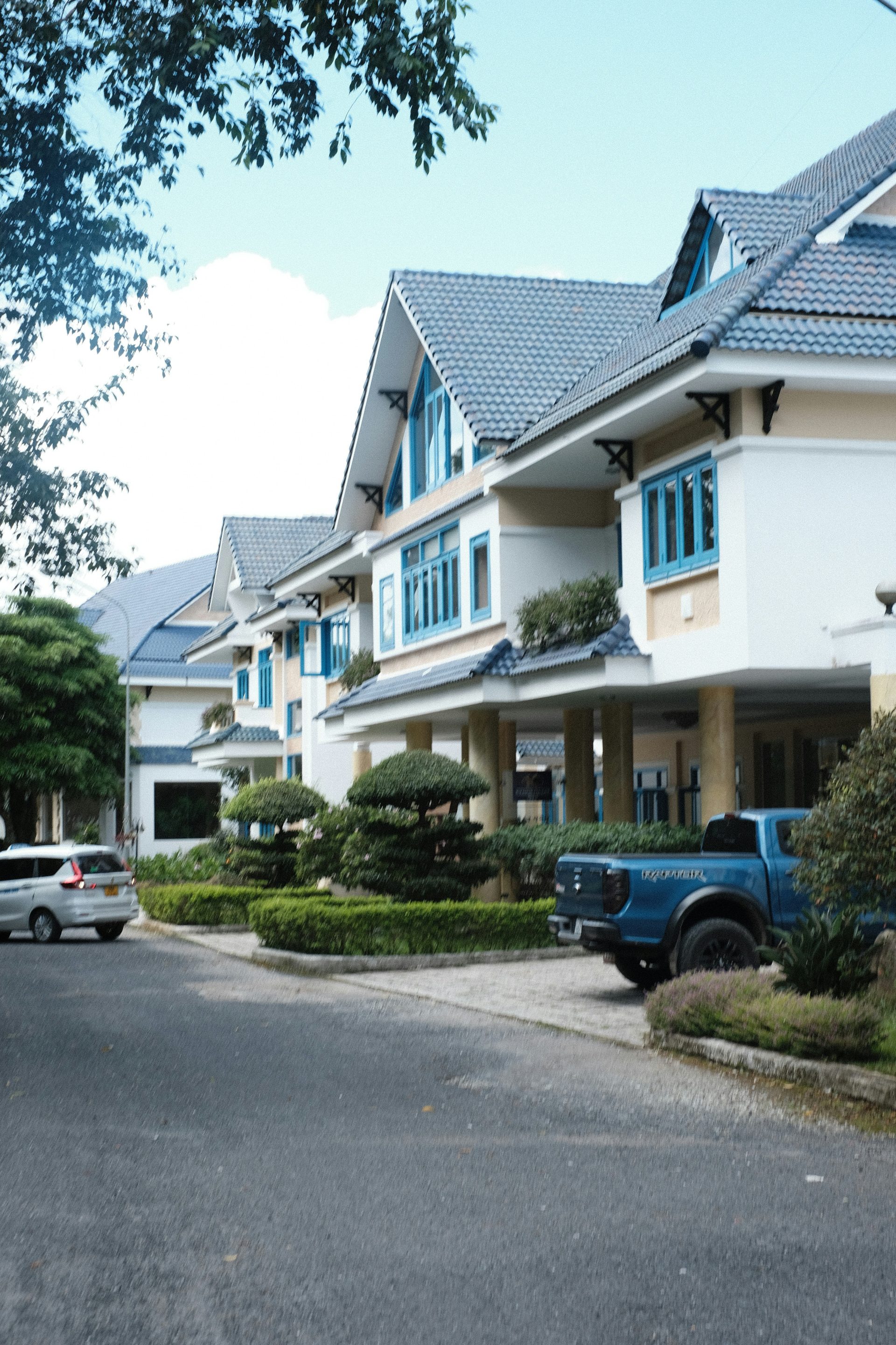 a blue truck is parked in front of a row of houses